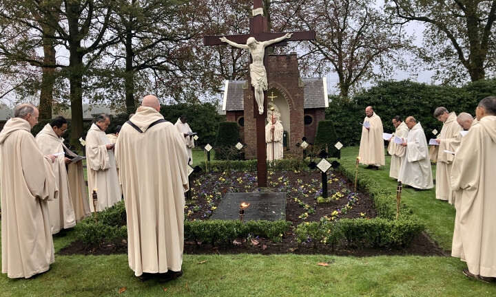 Bidden rond het kruis en de zerken van de overleden abten.