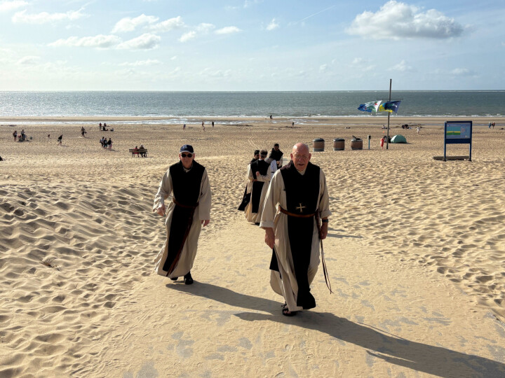 Dom Isaac en broeder Jakobus verlaten het mulle zandstrand, op weg naar de gereedstaande bus.